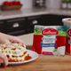 hand holding plate with lasagna with galbani cheese in background
